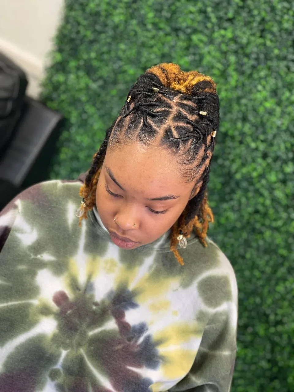 Gold-tipped locs pinned up, seen from above