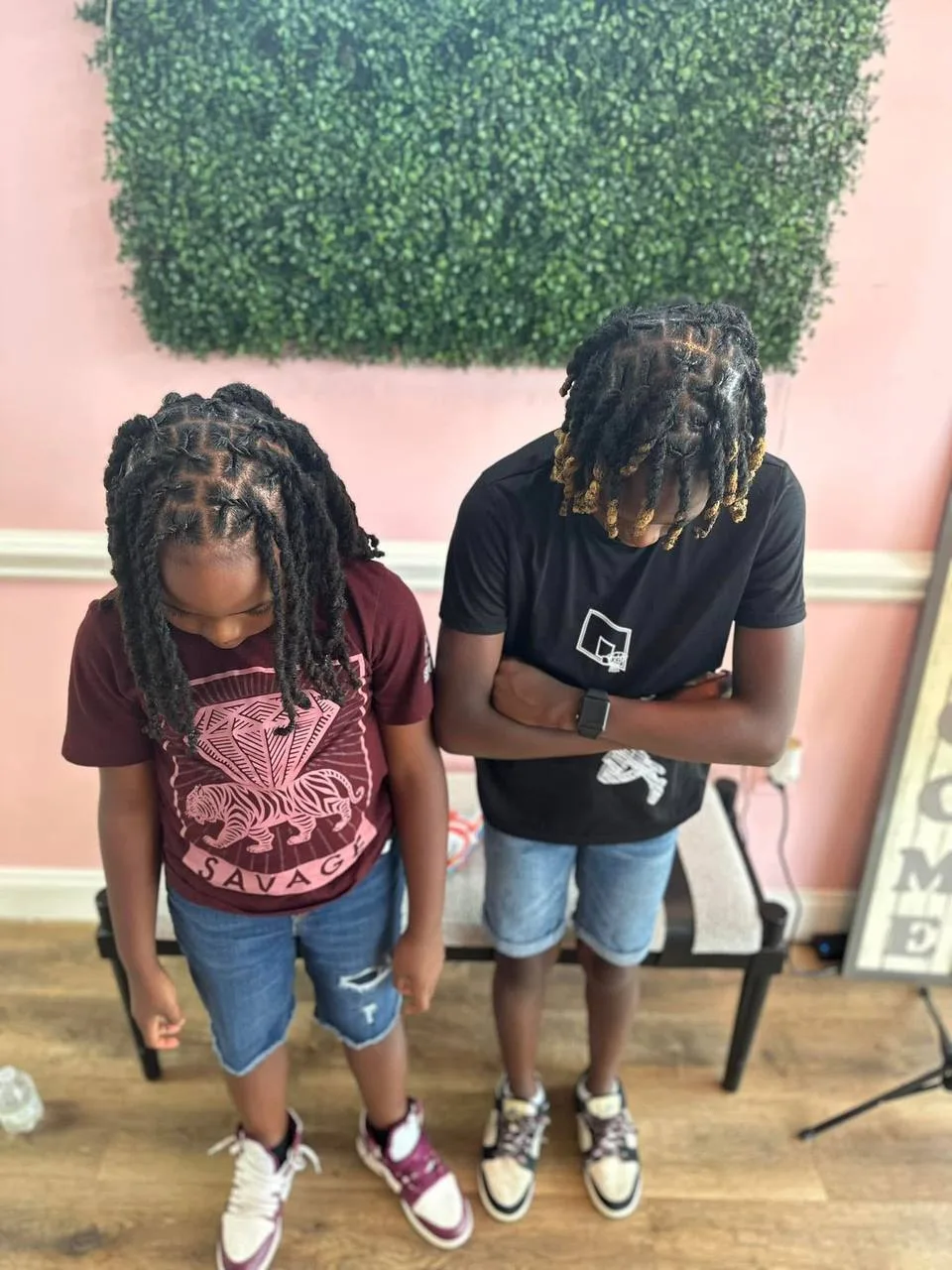 Two young siblings showing off their locs